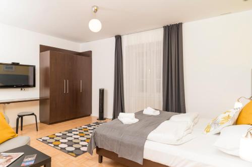 a bedroom with a bed and a desk and a tv at Stephansdom Premium Apartments in Vienna
