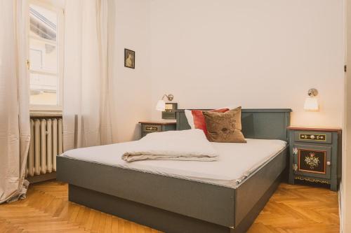a bedroom with a bed and two night stands at Das Bräu ORIGINAL in Lofer