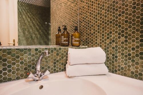 a bathroom sink with two bottles of soap and towels at Das Bräu ORIGINAL in Lofer