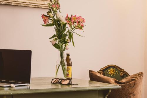 a table with a bottle of beer and a vase of flowers at Das Bräu ORIGINAL in Lofer