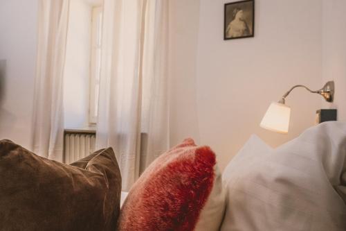 a living room with a couch with pillows and a window at Das Bräu ORIGINAL in Lofer