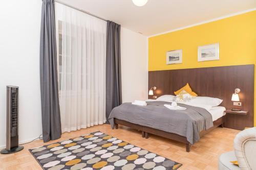 a bedroom with a bed and a yellow wall at Stephansdom Premium Apartments in Vienna