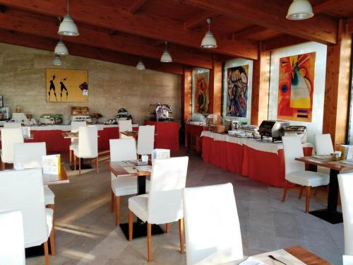 a restaurant with white chairs and tables and a counter at Holiday Inn Cagliari by IHG in Cagliari