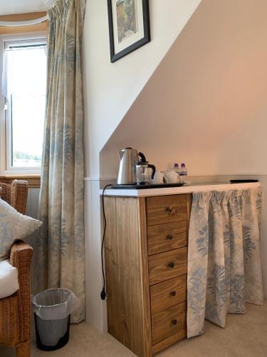 a room with a wooden dresser and a window at Dupplin152 bed and breakfast in Dundee