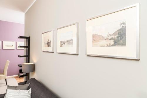 a row of framed art on a wall in a living room at Stephansdom Premium Apartments in Vienna