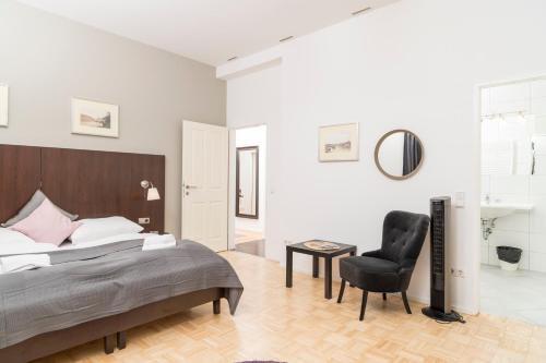 a bedroom with a bed and a black chair at Stephansdom Premium Apartments in Vienna
