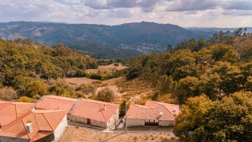 an aerial view of a house with mountains in the background at Casa dos Peliteiros in Vilarinho