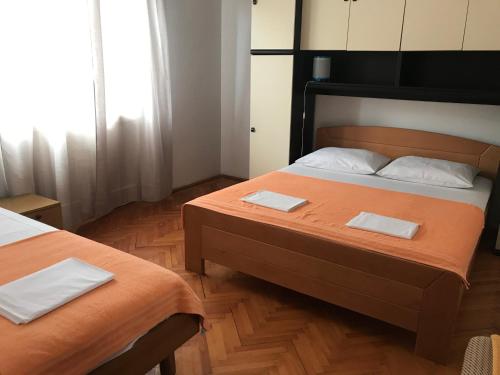 a bedroom with two beds with white towels on them at Apartmani Vilma Pakoštane in Pakoštane