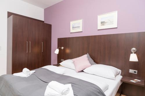 a bedroom with a large bed with a wooden headboard at Stephansdom Premium Apartments in Vienna