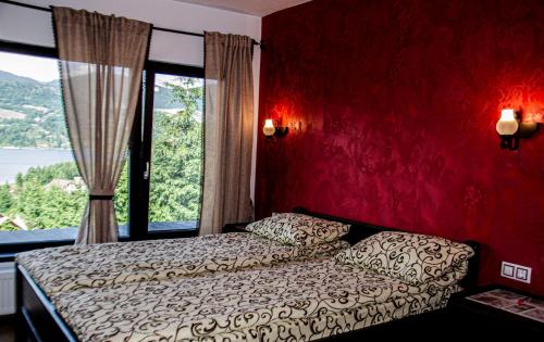 a bedroom with a bed and a large window at Vila Ozon 90 in Colibiţa