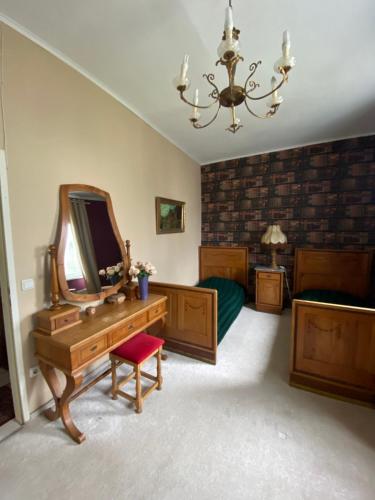 a bedroom with two beds and a vanity with a mirror at B&B Chardas in Bük