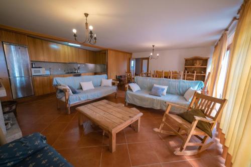 a living room with blue couches and a table at Casa dos Peliteiros in Vilarinho