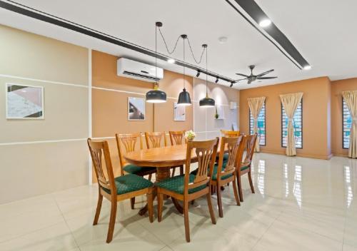 a dining room with a wooden table and chairs at Suraya Homestay Semi-D in Sepang
