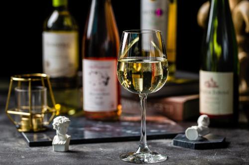 a glass of wine on a table with bottles of wine at Crowne Plaza Suzhou by IHG in Suzhou