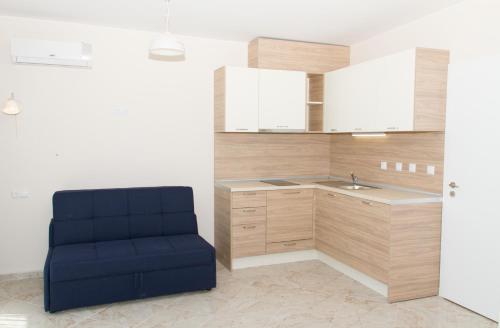 a blue chair in a kitchen with a sink at Apart Allure Dobi in Primorsko