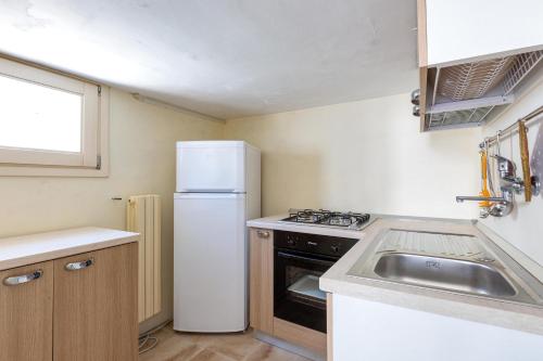 a small kitchen with a refrigerator and a sink at Antica dimora stasi by BarbarHouse in Presicce