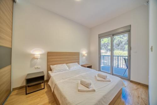 a bedroom with a large bed with two towels on it at Trsteno Beach Apartments in Budva