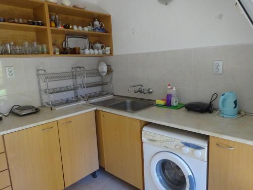 a kitchen with a sink and a washing machine at Hris in Chernomorets