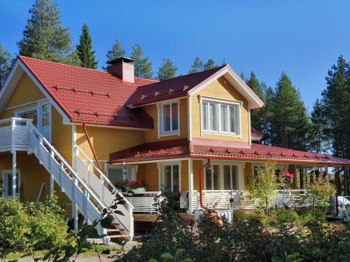 a yellow house with a red roof at TOIVONNIEMEN KOTIMAJOITUS 