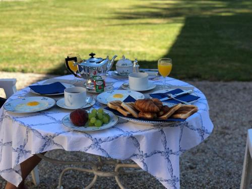 - une table avec une assiette de pain et des fruits dans l'établissement Chambres d'hôtes Saint Denis, à Mézières-sur-Issoire
