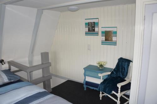 een slaapkamer met een bed, een stoel en een tafel bij Knus vertoeven in een historisch pand in Grou. in Grou