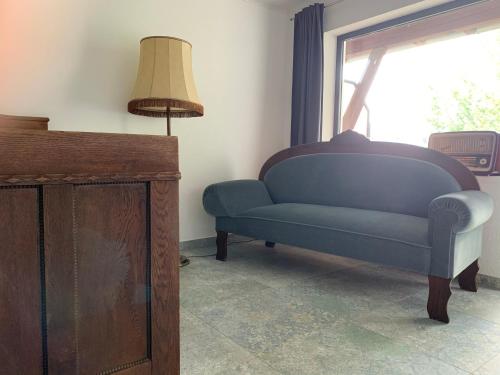 a blue couch in a living room with a window at Kubacher Hof in Kubach