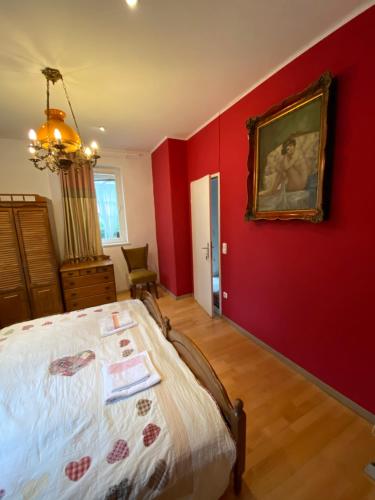 a bedroom with red walls and a bed and a painting at B&B Chardas in Bük
