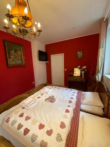 a bedroom with a large bed with red walls at B&B Chardas in Bük