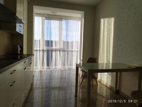 a kitchen with a table and a large window at ВІП апартаменти район автовокзалу ЖК Арена,ЖК Great House in Rivne