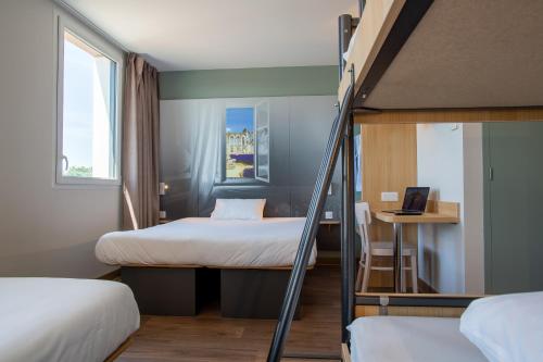 Un pat sau paturi într-o cameră la B&B HOTEL Les Herbiers