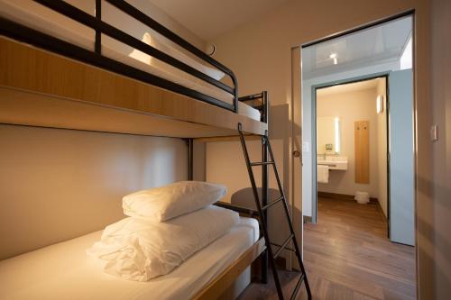 a room with two bunk beds and a hallway at B&B HOTEL Les Herbiers in Les Herbiers