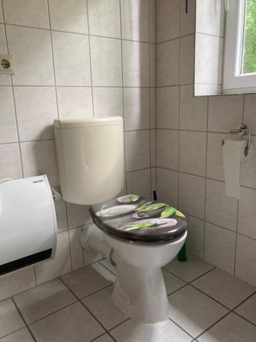 a bathroom with a toilet with a black seat at Haus Wald und Wiese Wohnung Wiese in Ehndorf