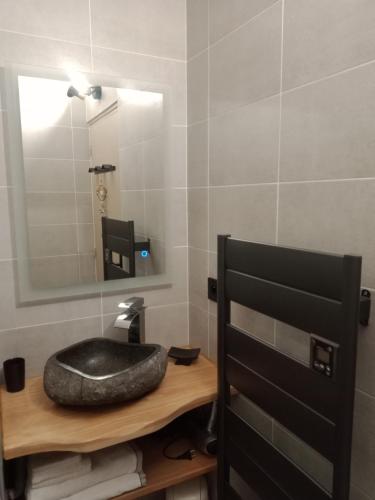 une salle de bain avec un lavabo noir et un miroir dans l'établissement appartement montagne- le petit Chaillol, à Saint-Michel-de-Chaillol