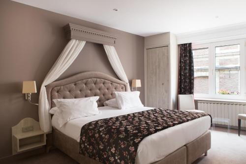 a bedroom with a large bed with a canopy at La Terrasse in Douai