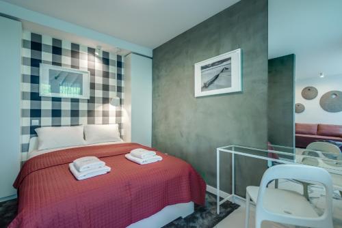a bedroom with a red bed and a chair at CHILLIapartamenty - Platany - POWDER in Kołobrzeg
