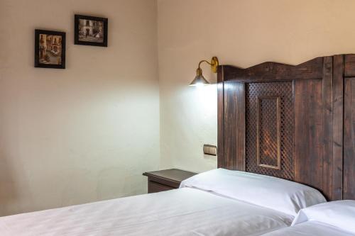 a bedroom with two beds and a wooden headboard at Hotel Sao Joao De Deus by RIDAN Hotels in Elvas