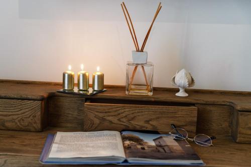 a book and candles on a wooden table with a book at Palazzo Sant'Anna Lecce in Lecce