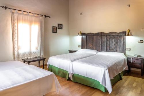 a hotel room with two beds and a window at Hotel Sao Joao De Deus by RIDAN Hotels in Elvas