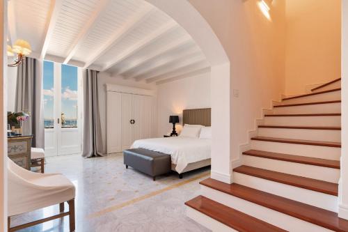 a bedroom with a bed and a staircase leading to a bedroom at Palazzo del Corso – Boutique Hotel in Gallipoli