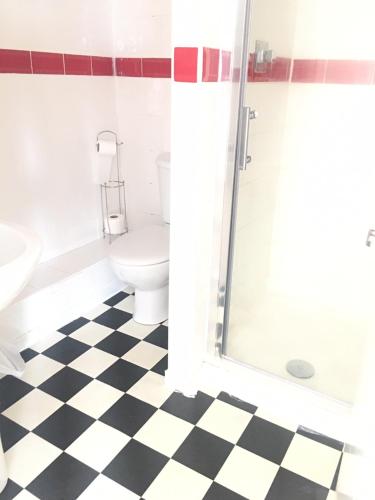 a bathroom with a black and white checkered floor at Sunny Days Hotel in Blackpool