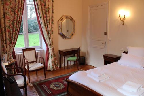 a bedroom with a bed and a mirror and a window at Château de Lannouan in Landévant