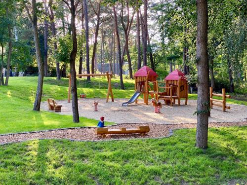 ein Kind, das auf einem Spielplatz im Park spielt in der Unterkunft Hotel Residenz WALDOASE in Ahlbeck