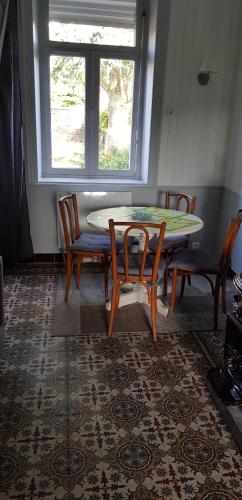 une salle à manger avec une table et des chaises et une fenêtre dans l'établissement Cosy Cottage, à Beugin