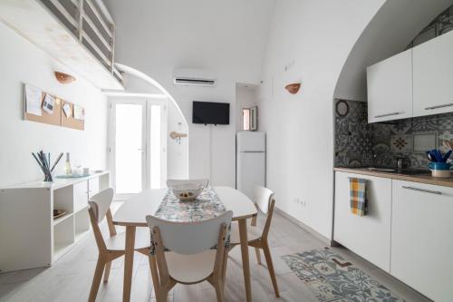 a kitchen and dining room with a table and chairs at La Nghioscia in Grottaglie