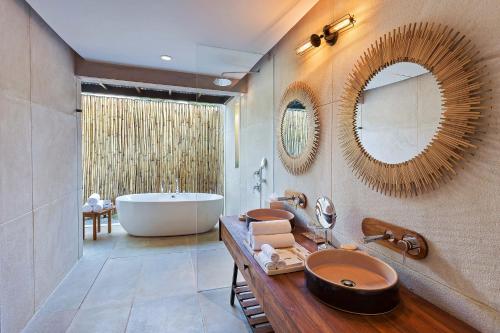 a bathroom with a tub and two sinks and a bath tub at Woods at Sasan in Sasan Gir