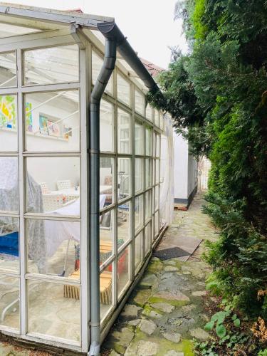a greenhouse with large glass windows in a garden at B&B Chardas in Bük