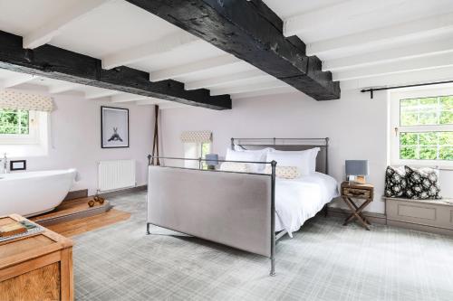a bedroom with a large bed and a bath tub at The Hideaway at Tregoose Old Mill in Newquay