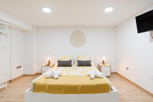 um quarto branco com uma grande cama com lençóis amarelos em Duplex Cienfuegos & old town by ELE Apartments em Málaga