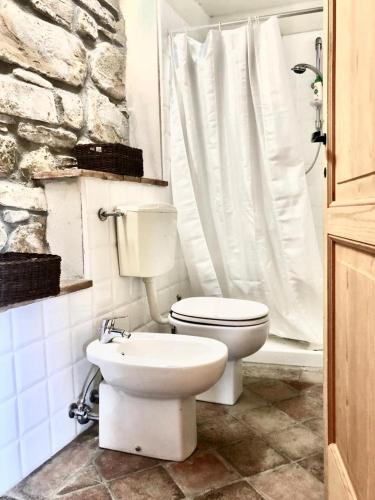 a bathroom with a white toilet and a shower at Nido d’amore nei colori in Dernice