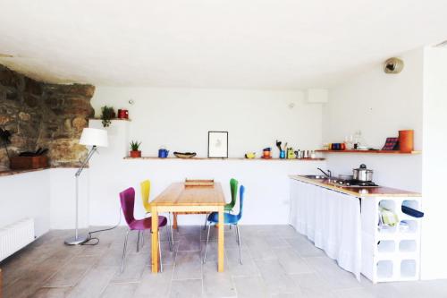 a kitchen with a wooden table and chairs at Nido d’amore nei colori in Dernice